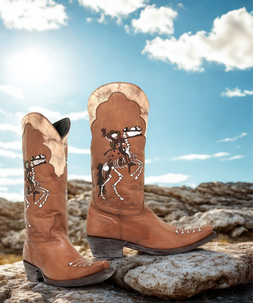 The Old Gringo Ghost Rider Boots, inspired by the Dia De Los Muertos Holiday in Mexico, are full of personality. The Tan  leather is decorated with a skeleton cowgirl on her skeleton horse rearing up for a big ride.  The distinctive artwork and intricate design of the Old Gringo Ghost Rider Boots make them the ultimate conversation piece! This pair of Ghost Rider's offer hidden boot pulls, located inside the boot shaft.  These brand new boots are part of our sample collection and have never before been offered for sale.

Measurements:

Shaft Height - 13"
Heel - 9964
Toe - 4L (snip) 