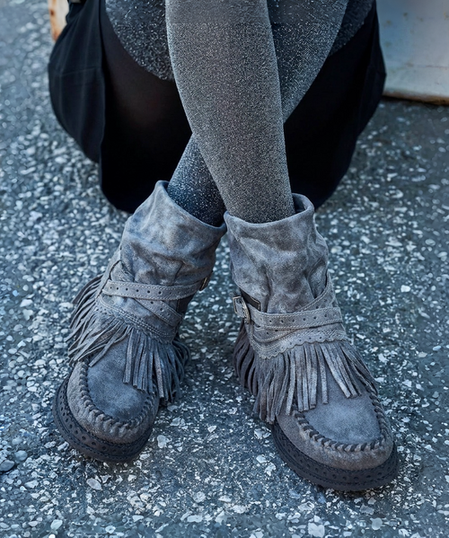 The Clint Boot by El Vaquero is a striking over-the-knee silhouette that blends refined craftsmanship with effortless summer elegance. Distinguished by a sleek ankle strap and beautifully detailed leather accents along the shaft, this boot delivers unmistakable style with a soft, artisanal feel.

Crafted in Italy from a unique combination of luxurious calfskin suede and fine natural linen, Clint offers a fresh, lightweight construction that’s perfect for warm-weather styling. The subtle 7 cm internal wedge provides comfortable lift without compromising ease, while the vintage treatment adds character and depth to every pair.

Finished with handcrafted stitching, nickel-free metal details, and a durable rubber sole, the Clint boot is designed for confident, all-day wear. Elegant yet relaxed, it pairs effortlessly with flowy dresses, tailored shorts, or layered summer looks.

Details:

Over-the-knee boot

Internal wedge: 7 cm

Vintage treatment

100% calfskin suede and natural linen

Handcrafted stitching

Nickel-free metal details

Rubber sole

Made in Italy