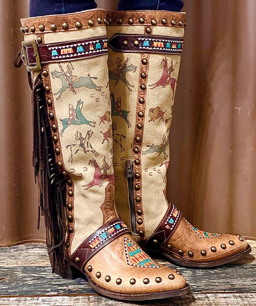 Ledger art is a traditional Native American art form that dates back to the mid-1800s, and it usually consists of scenes and symbols being drawn or painted onto things like old accounting ledgers or stock certificates, as that type of paper was most readily available in that time period. We’ve always found it intriguing and beautiful, and we were beyond excited to collaborate with a very talented Native American artist to create this ledger art design and incorporate it into the Matagorda collection. This boot has a tall, straight silhouette with the imagery subtly incorporated on the shaft, trimmed with complimentary brown leather and studding, and accented by elements of embroidery. And, of course, the extra bit of awesome that a long strip of fringe adds!

toe: pointed round
heel: riding heel - 9964 Walking Heel
shaft height: 16"
leather: distressed suede with leather piecing
features: printed imagery, embroidery, studs, fringe, strap with buckle detail, lacing detail in back, short side zipper
collection: I Go Back