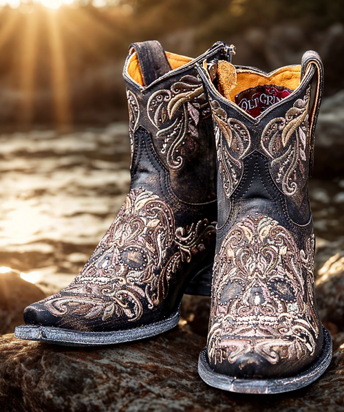Note - Custom Order sizes due to arrive 90 - 120 days from order date. 

Meet the ever-popular Dulce Calavera collection by Old Gringo Boots! This striking ankle boot blends neutral-toned leathers with vibrant embroidered sugar skulls for a bold, playful twist on a classic western style.

Featuring edgy stud detailing and a convenient side zipper for easy on-and-off wear, these boots are as functional as they are fierce. Perfect for adding a splash of attitude to your everyday look or making a statement at your next outing.

Details:

Shaft Height: 7"

Shaft Opening: 13.5" circumference

Heel Height: 1¾"

Toe: Snip

Style: Ankle boot with side zipper

Design: Embroidered sugar skulls + stud accents

Add a little spice to your boot collection with these bad to the bone beauties, cowgirl!
