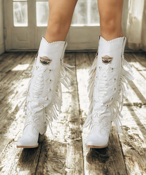 The most striking feature of our Katherine boot is the incredible attention to details. This pointed toe model features a 2 3/4" heel, side fringes and leather patterns and motifs around the ankle. Featuring carvings on the shaft with the addition of metallic elements, this western-style boot is then finished with the vintage treatment that gives wonderful shades to the leather. Available in this Carmel Silverstone color dreaming of amazing destinations around the world has never been easier.

Heel - 2 3/4" leather stacked heel

Toe - Sintino style toe

Height - 17"

Handmade stitching

Hand-inserted details