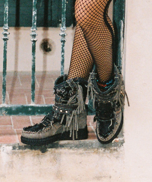 Symbol and icon par excellence of the brand, Arya has defined the recent history of El Vaquero becoming the leading character of its tale of freedom and wildness. Featuring our signature handmade stitching, side fringing and hardware embellishments, the Arya boot is presented in this revolutionary combination of prime quality black denim and brushed leather.