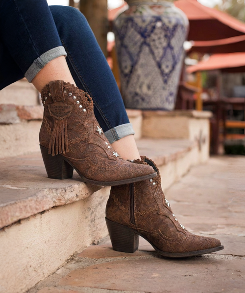Violet is our Texan ankle boot enriched with beautiful leather details, cool studded detailing along the top, fringes and an elegant turquoise bead on the front. With its thick 70 mm heel and side zip, Violet is suitable for the most elegant occasions without sacrificing comfort. Created in this stunning brown flower engraved suede leather with on tone details, lightly washed and tinted with our cutting-edge vintaging technique providing a strong and innovative look. Available in this color inspired by nature and the environment, with contrasting leather details.

Heel 7 cm
Vintage Treatment
100% Calf suede
Handmade Stitching
Hand-inserted details
Metal details 100% nickel-free
Leather details
Leather sole
Made in Italy