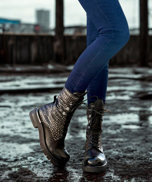 The 'Ruby' line of genuine leather boots follows current trends by overturning the traditional footwear paradigm. Characterised by the use of a large rubber heel and a reinterpretation of the dimensions, this collection is distinguished by a special detail: a metal element positioned on the underside of the heel. This detail not only promotes a distinctive aesthetic, but also gives the 'Ruby' boots a striking and contemporary look.