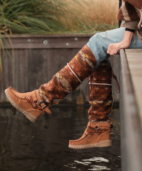 Huntress Boot – Elevated Wild Elegance
Bold in stature and effortless in style, the Huntress Boot is a signature El Vaquero bestseller, instantly recognizable by its knee-high silhouette and unmistakable craftsmanship. This moccasin-inspired design features a discreet 2¾" internal wedge for subtle lift, a supportive ankle strap, and hand-sewn detailing that speaks to the brand’s artisanal roots.

Crafted in a revolutionary mix of suede calfskin and tribal-patterned cotton fabric, the Huntress Boot brings earthy texture and visual depth to every step. Inside, a boiled wool fur lining offers cozy warmth, making this boot ideal for colder months without compromising style. Finished with nickel-free metal accents, leather trims, and a durable rubber sole, the Huntress is the perfect fusion of bohemian edge and elevated comfort.

Product Details:

Wedge: 2¾" (7 cm) internal lift

Materials: Premium calf suede & tribal-patterned cotton

Lining: Boiled wool fur for warmth and softness

Construction: Handcrafted stitching with ankle strap support

Hardware: 100% nickel-free metallic details

Accents: Leather trims, vintage-inspired finish

Sole: Rubber for traction and durability