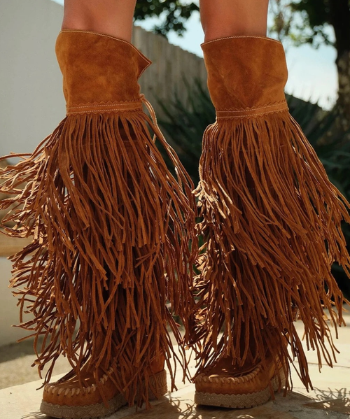 Note - Custom Order sizes due to arrive 90 - 120 days from order date. 

Esme is the knee-high boot from El Vaquero that embodies the free spirit of boho-western. Featuring a 2 3/4" internal wedge, an adjustable back lacing, and a cascade of multi-level fringe, it's embellished with handcrafted stitching and carved details. A dramatic model, designed for those who love to stand out in style. Crafted from this suede calfskin with a vintage finish, enhanced by the renowned Silverstone wash. Each hide is unique, with intense hues and a worn-in effect that tells a story.

Internal wedge 2 3/4"
Vintage Treatment
100% Calf Suede
Handcrafted stitching
100% nickel-free metal details
Rubber sole
Made in Italy