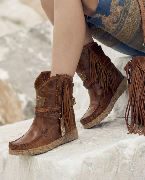 Known as the very emblem of the brand, the Arya boot has written a pivotal chapter in El Vaquero\'s history, becoming the undisputed protagonist of its tale of freedom and independence. Its distinctive features, such as handmade stitching, soft side fringes, and metallic details, make Arya an indispensable icon within the El Vaquero collection. Scratched and lightly washed with our feature ageing technique called Silverstone which creates amazing color fluctuations on the suede leather, defining the unique character of our boots. Available in this classic tone of autumnal woods nature, with on tone details and natural leather threading.

Hidden wedge 2 3/4"

Calf suede

Vintage Treatment
Handmade Stitching
Metal details 100% nickel-free
Leather details
Rubber sole
Made in Italy