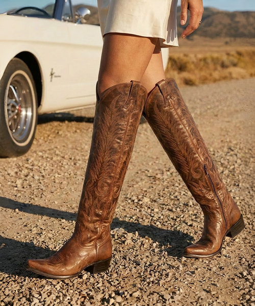 A true Western icon, the Old Gringo Mayra is the definition of timeless craftsmanship. Handcrafted from richly distressed leather with a naturally weathered patina, this legendary tall boot combines authentic cowboy heritage with understated elegance, creating a style that only becomes more beautiful with age.

The supple cognac leather is hand-finished to showcase subtle highs and lows in color, giving every pair its own unique character. Intricate tonal embroidery climbs the tall shaft in flowing flame-inspired patterns, adding texture and dimension without overpowering the clean, classic silhouette.

A flattering snip toe, traditional cowboy heel, and extra-tall shaft create the unmistakable profile that has made the Mayra one of Old Gringo's most sought-after and enduring designs. Hidden inside is a full-length zipper that offers effortless on-and-off convenience while preserving the sleek, uninterrupted lines of the boot.

Whether paired with distressed denim, flowing maxi dresses, or layered bohemian styles, the Mayra delivers effortless sophistication that transcends trends.