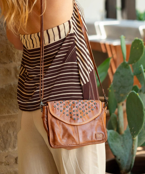 Occurrence is the compact crossbody that packs a punch. Adorned with bold studs on the flap, this versatile bag can be worn as a crossbody or transformed into a clutch by removing the strap. Small but mighty, Occurrence offers just enough space for your essentials while making a statement with its edgy yet elegant design. Perfect for day or night, it's the ultimate grab-and-go accessory.