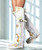 The Coleen is a must-have in the wardrobe of every loyal customer of our brand. This boot featuring an over the knee fit has a reinforced shaft that ensures its stability over time and the typical handmade stitching on the instep, distinctive feature of El Vaquero brand. Featuring an elegant and unbelievable soft white calf with hand-painted flowery details. 

2 3/4" Internal wedge heel

1 1/2" wedge sole

Leather logo tag

Stitching details

Unlined

Rubber sole

Made in Italy

Composition: 100% Calf
