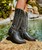 The Clint Boot by El Vaquero is a striking over-the-knee silhouette that blends refined craftsmanship with effortless summer elegance. Distinguished by a sleek ankle strap and beautifully detailed leather accents along the shaft, this boot delivers unmistakable style with a soft, artisanal feel.

Crafted in Italy from a unique combination of luxurious calfskin suede and fine natural linen, Clint offers a fresh, lightweight construction that’s perfect for warm-weather styling. The subtle 7 cm internal wedge provides comfortable lift without compromising ease, while the vintage treatment adds character and depth to every pair.

Finished with handcrafted stitching, nickel-free metal details, and a durable rubber sole, the Clint boot is designed for confident, all-day wear. Elegant yet relaxed, it pairs effortlessly with flowy dresses, tailored shorts, or layered summer looks.

Details:

Over-the-knee boot

Internal wedge: 7 cm

Vintage treatment

100% calfskin suede and natural linen

Handcrafted stitching

Nickel-free metal details

Rubber sole

Made in Italy