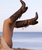 This is a stylish beachside fashion shot focused on a pair of tall western boots as the hero piece. The model is reclining on warm sand near the shoreline, with the calm ocean and pale sky softly blurred in the background. Her legs are raised playfully in the air, drawing full attention to the boots.

She’s wearing tall bronze snakeskin leather boots with a subtle metallic sheen. The boots feature layered fringe along the shaft, decorative stitching, and a sturdy block heel. The texture of the snakeskin catches the light beautifully, giving the boots a luxurious, statement look.

Overall mood: playful, romantic, and coastal-western glam—sunset light, relaxed pose, and the boots showcased as bold fashion art.