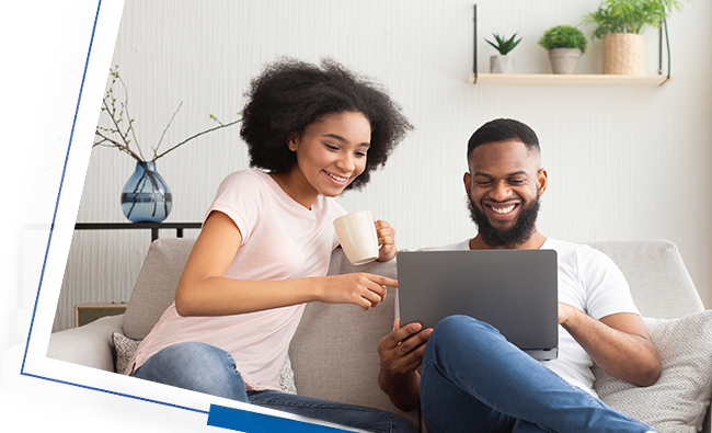 Couple sitting on the couch looking at a laptop