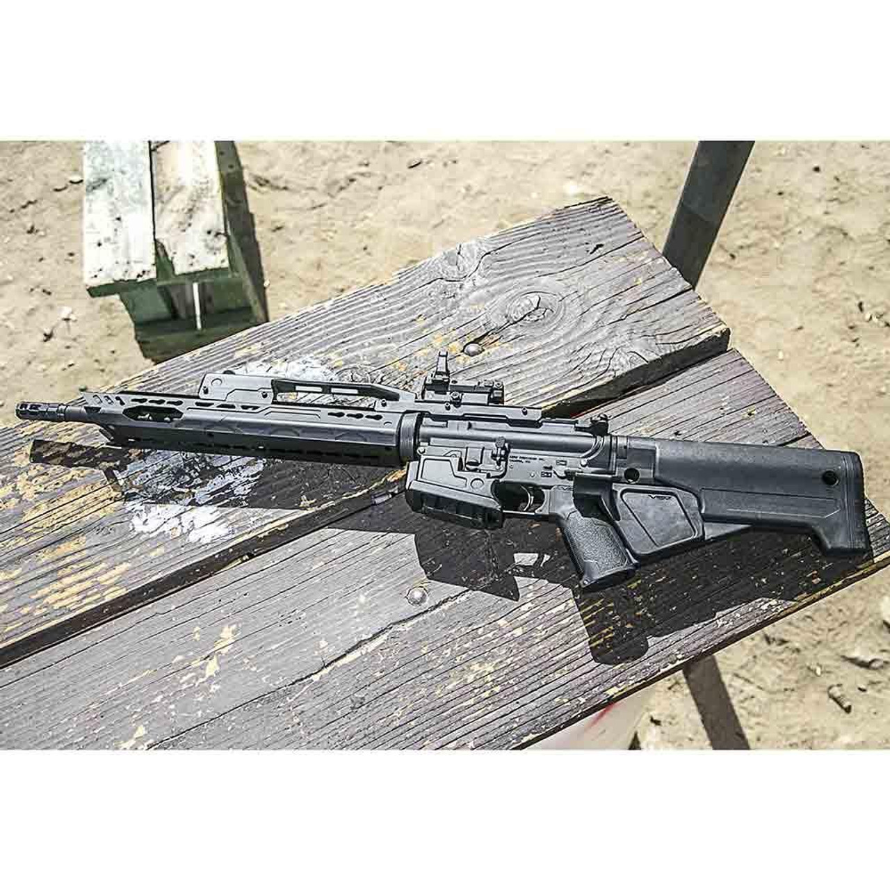 NcStar NcSTAR VKARB1 BlastAR AR15 Stock Kit with Handguard, Carry Handle, Magwell and Featureless Grip, black assault rifle with adjustable stock and modern tactical design lying on a wooden surface outdoors.