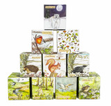 A pyramid display of ten Heaven Scent 20cl illustrated vegan soy candles in boxes, featuring designs like Northern Lights (polar bear), Cold Still Days (robin), Autumn Days, Winter Ramble (hedgehog), Frosty Morning (squirrel), Midwinter (badger), Breezy Days, Mossy Dell (hare), Summer Meadows (owl), and Primrose Lane (wren).