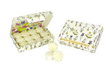 A box of Wild Flower scented wax melts in the shape of flowers, shown both inside their illustrated gift box and resting beside it. The FSC-certified packaging features a delicate botanical pattern by Sarah Pettitt including bluebells, clover and iris on a clean white background.