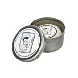 Heaven Scent natural vegan shaving soap bar wrapped in glassine paper inside an open, brushed metal travel tin featuring a black and white illustrated woman shaving, scented with Lavender, Sweet Orange and Geranium.