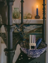 A beautifully illustrated, blue-striped gift box for Heaven Scent's The Blue Edit mixed dinner candles, displayed alongside six straight, hand-poured artisan dinner candles in complementary shades of Pastel Blue, Navy Blue and Charcoal Grey.