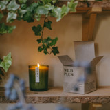 20cl natural soy wax Wild Plum scented candle in a beautiful green glass jar, next to its recycled presentation box, hand-poured in the UK.