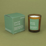 Winter Thyme 20cl amber glass scented candle from the Modern Heritage collection, shown beside its green gift box.