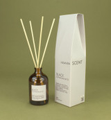 Black Pomegranate 100ml amber apothecary glass reed diffuser from the Modern Heritage collection, shown with natural rattan reeds and its white/neutral gift box.