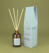 Relaxing 100ml amber apothecary glass reed diffuser from the Modern Heritage collection, shown with natural rattan reeds and its pale blue gift box.