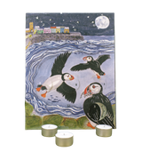 Coastal Puffins 12-Day Christmas Tealight Advent Calendar featuring an illustrated coastal puffin and harbour design by Sarah Pettitt, displayed alongside three individual tealights in recyclable aluminium cups.