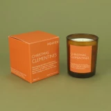 Festive Christmas Clementines 20cl amber glass scented Christmas candle from the Modern Heritage collection, shown beside its bright orange gift box.