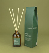 Pine Needles 100ml amber apothecary glass Christmas reed diffuser from the Modern Heritage collection, shown with natural rattan reeds and its tree green box gift box.