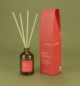 Spiced Orange 100ml amber apothecary glass Christmas reed diffuser from the Modern Heritage collection, shown with natural rattan reeds and its deep orange box gift box.