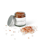 Close-up of a 140g clear glass pharmacy jar filled with pink Himalayan bath salts, ready for a calming soak.