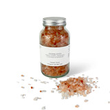 Close-up of a 300 g clear glass bottle filled with pink Himalayan bath salts, ready for a calming soak.