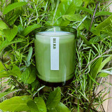 20cl natural soy wax Herb-scented candle in a beautiful green glass jar, next to its recycled presentation box.