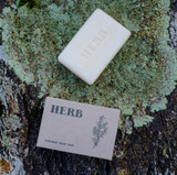 Herb 100g Green Botanical natural soap bar shown with its recycled card box packaging featuring a botanical herb illustration and the stamped soap bar.