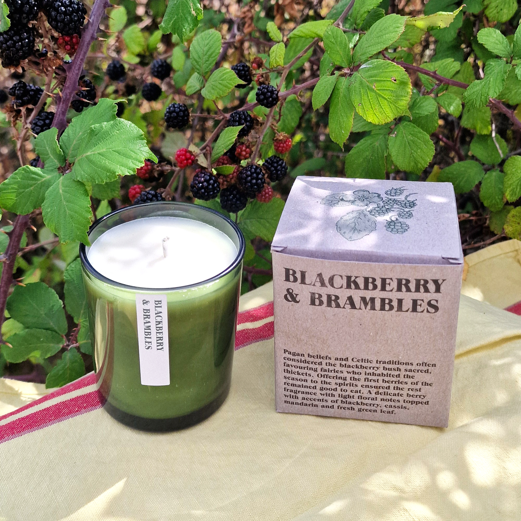 Heaven Scent Blackberry & Brambles candle, in front of autumnal blackberries
