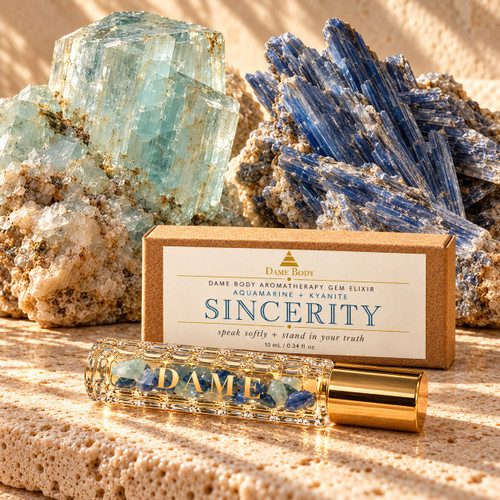 Sincerity 10 mL crystal roller and labeled kraft box with raw Aquamarine and Kyanite on warm cream stone.