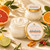 Open Citrus + Agave Body Butter showing its rich ivory texture beside the approved orange-and-gold lid label.