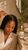 Adult Black woman applying Crown Ritual with a precision dropper along exposed scalp sections between braids, beside the corrected 3.4 fl oz bottle.