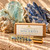 Sincerity 10 mL crystal roller and labeled kraft box with raw Aquamarine and Kyanite on warm cream stone.