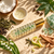 Serenity roller with coconut, castor, Aventurine and props representing its fragrance notes.