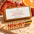 Cranberry Sweet Orange 10 mL aromatherapy roller and labeled kraft box with Red Agate and Red Jasper.