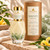 Close view of Serenity Perfume in faceted glass with green aventurine chips, gold cap and matching labeled kraft tube.