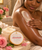 Dame gently smoothing Rose Nectar Body Butter over her arm during her moisture ritual.