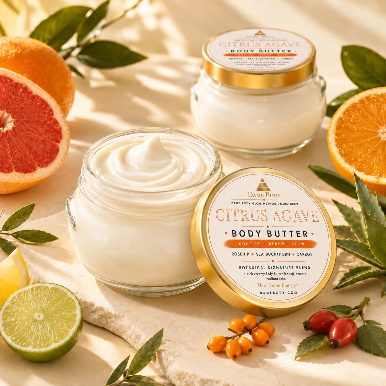 Open Citrus + Agave Body Butter showing its rich ivory texture beside the approved orange-and-gold lid label.