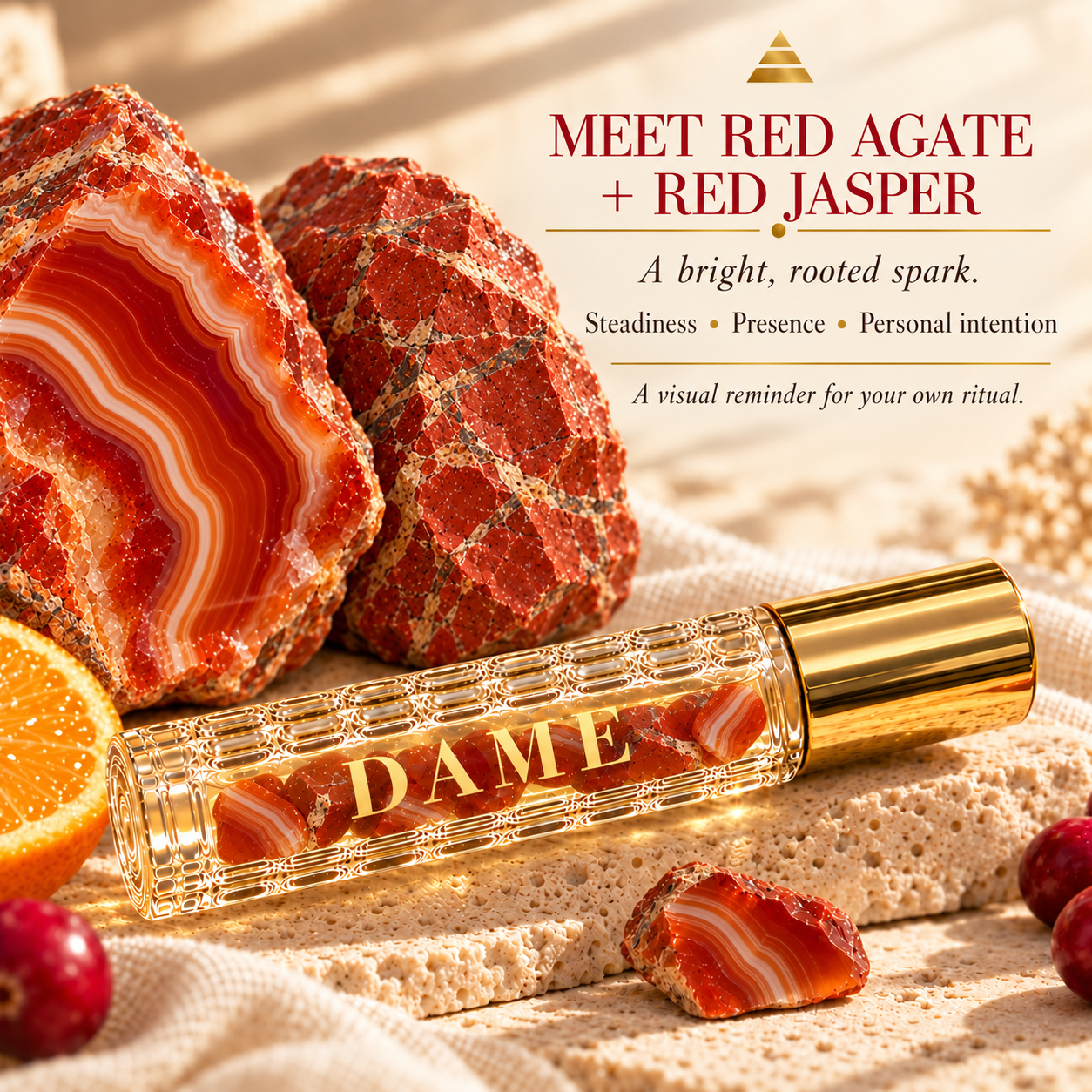 Cranberry Sweet Orange roller beside banded Red Agate and rough Red Jasper specimens.