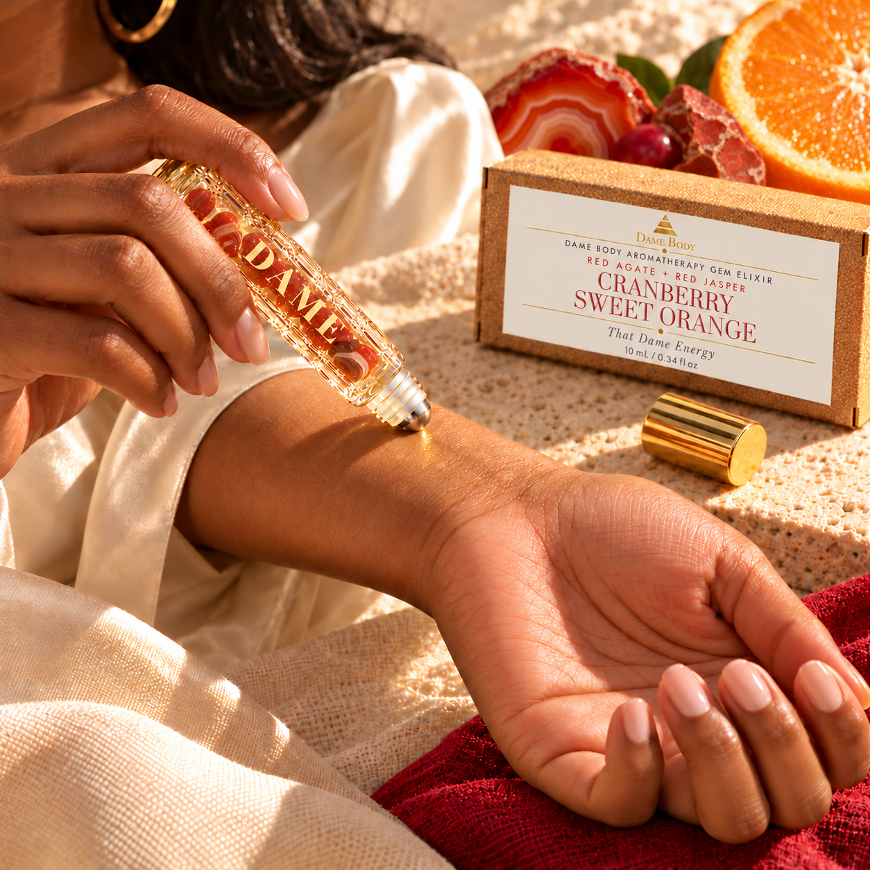 An adult woman lightly applies the Cranberry Sweet Orange metal roller ball to her inner wrist.