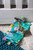 Finalist for the 2019 Progressive Preschool Awards in the ‘Best Infant Development’ category

6×6″ Taggies was born over a decade ago when a mom noticed her child’s fascination with satin tags. This idea blossomed into a world of treasured products.

Little ones are mesmerized by rubbing these soft, satin loops. Exploring Taggies textured tags can provide tactile stimulation that babies crave for development and have an amazing calming effect on little ones. Discover the secret too!

Taggies books are winning awards for their combination of stimulation (squeaker and crinkle paper inside) and soothing features (eight Taggies ribbons and textured fabric covers). Each book tells a short, sweet story in eight pages with Velcro® closure.

Begin each day with a long, slow hug. In the Baby market, sloths are hot! Molasses is our “cute” version of a realistic sloth. Molasses Sloth is a truly gender neutral buddy. Naturally neutral color palette. Sloth is incredibly adorable, with a captivating face, and tags all over.

– 6×6″ Soft book featuring Taggies Molasses Sloth in a fun, calming, short bedtime story
– 2-dimensional book with 3-dimensional details
– On-trend greenery
– Fabric applique cover
– All-emboridered details
– Lots of Taggies ribbons
– 8 pages
– Velcro® closure
– Crinkle paper and squeaker inside
– Coordinates with the Molasses Sloth collection
– Machine wash, air dry