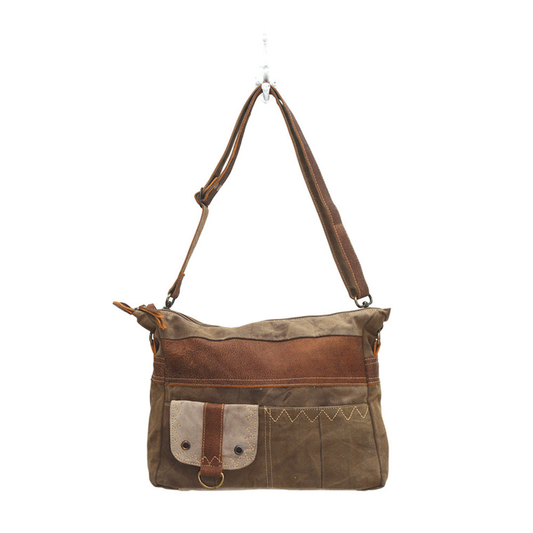 As the name suggests, this bag calls for a perfect adventure. This features two front pocket as well as a Flap-over closure. Made of upcycled canvas and leather.