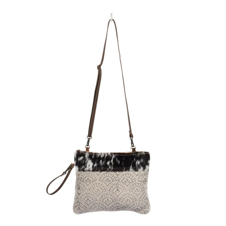 The combination of cotton rug with black and white shaded hairon looks fab. This small bag has a beautiful design to compliment your style. You can use this bag as wristlet as well as cross body bag.

Made of upcycled canvas and leather.