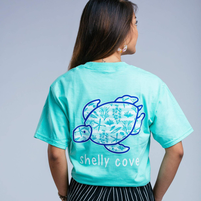 Feel comfortable in your Shelly Cove…
Garment dyed short sleeve in Clean Mint
Island Marina 5 color turtle design
Garment washed for softness
Left chest with Shelly Turtle
Preshrunk 6.1oz 100% ringspun cotton
Unisex sizing
Printed in America

*Portion of each sale goes directly to seaturtlehospital.org*

We recommend hand washing in cold water with mild soap.  Never use stain removers on garment washed items. Line drying recommended.